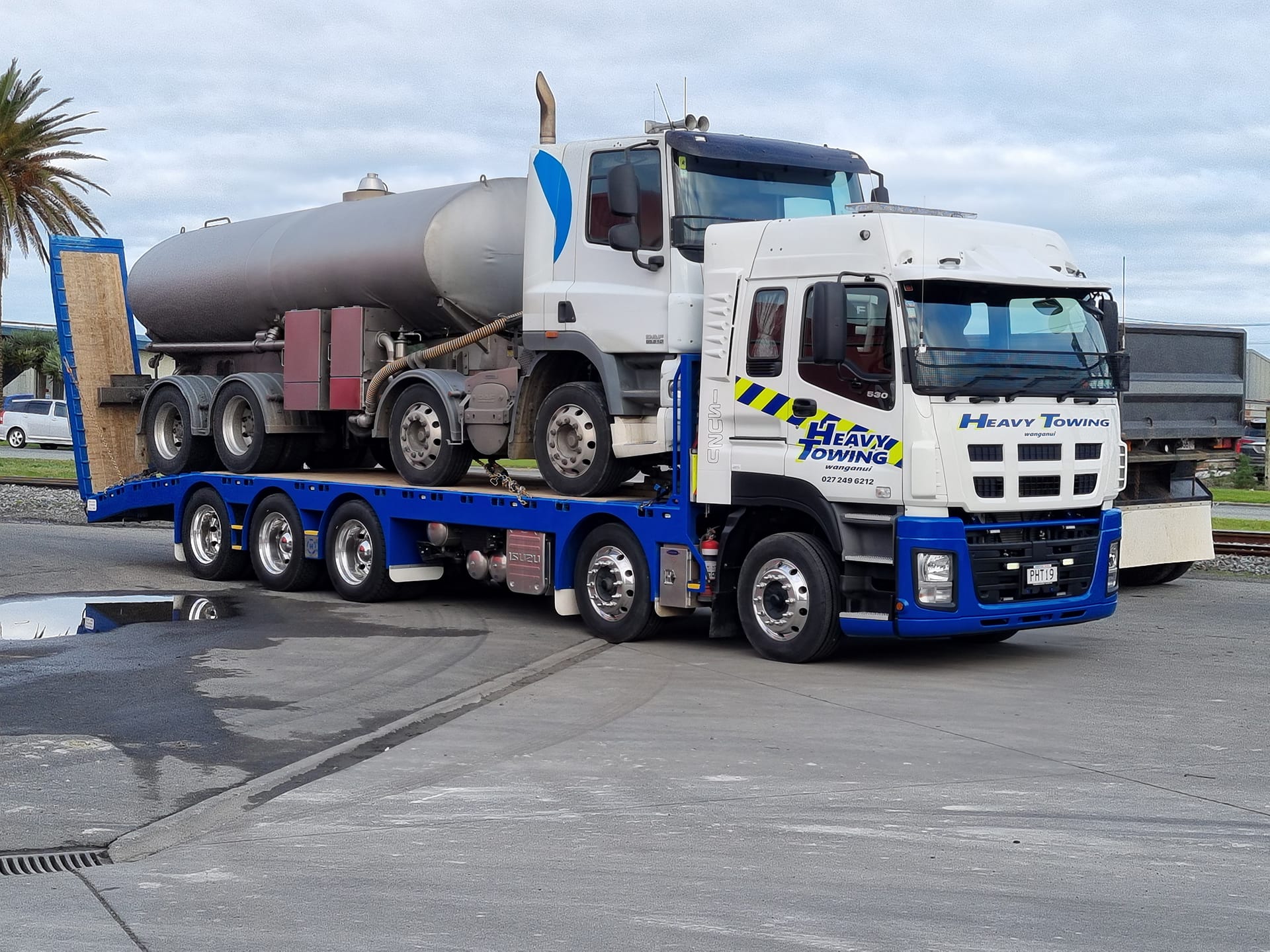 Heavy Towing truck transporting a tanker unit on a low-loader trailer